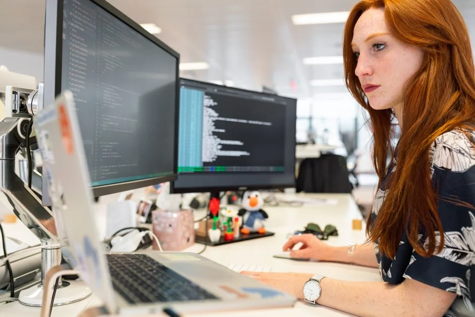 A contemporary computer monitor showing web design projects, with creative visuals presented in a workspace.